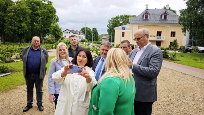 Attīstības padomes pārstāvji Iecavas muižas teritorijā iepazīstas ar muižas virtuālo versiju mobilajā ierīcē.