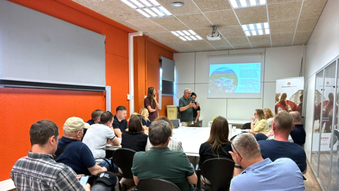 Zemgales reģiona pašvaldību pārstāvji apmeklē Kataloniju. Attēlā cilvēki sēž telpāu un uzklausa atkritumu apstrādes rūpnīcas pārstāvja prezentāciju